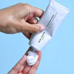 Model dispensing Silica Mud Mask into hand from tube