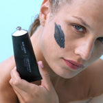 Model with Lava Scrub Mask applied to cheek holding tube