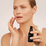 Model holding BL+ Retinol Cream 0.3% while applying product to face
