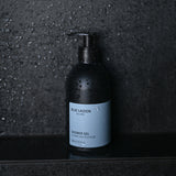 Shower Gel pump bottle standing on wet stone surface in shower setting