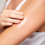 Model applying Body Oil to skin, lightweight oil that nourishes and enhances glow.