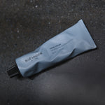 Hand Cream tube lying on dark stone surface