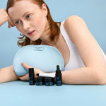 Woman holding a blue makeup bag with skincare products on a light blue background
